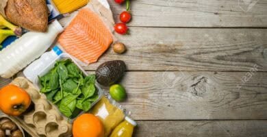 Lista de la Compra por 35€: Menú Completo para 7 Días (2026) 18 Vista aérea de una mesa con alimentos básicos económicos como verduras, arroz, pasta, huevos y pan, organizada para representar una compra semanal por bajo presupuesto.