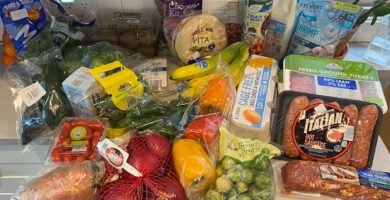 Compra semanal de alimentos por 40 euros con variedad de frutas, verduras, proteínas y básicos en una mesa de cocina, representando un menú económico y equilibrado.