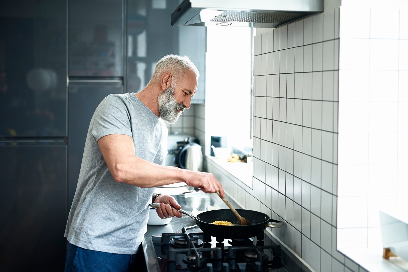 https://hips.hearstapps.com/hmg-prod/images/senior-man-with-grey-beard-using-frying-pan-in-royalty-free-image-1681996373.jpg